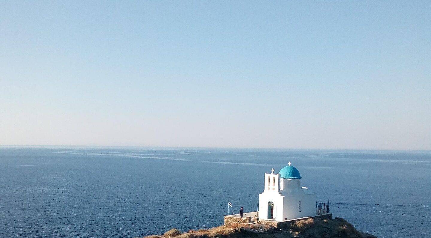 Peaceful terrace view of the sea and cacti in Santorini, Greece, during a sunny day.
